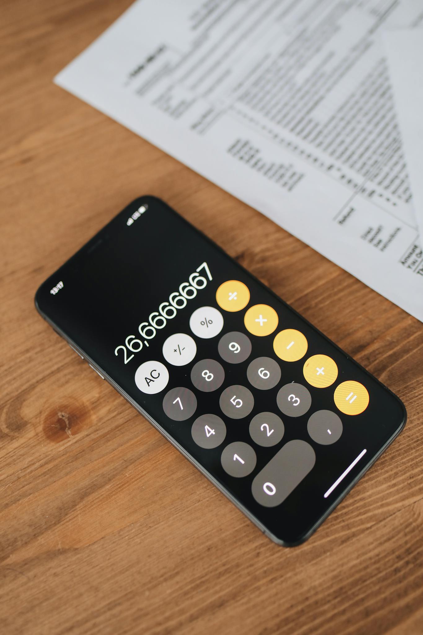 Black Calculator With Blur Image Of Tax Forms On Wooden Surface